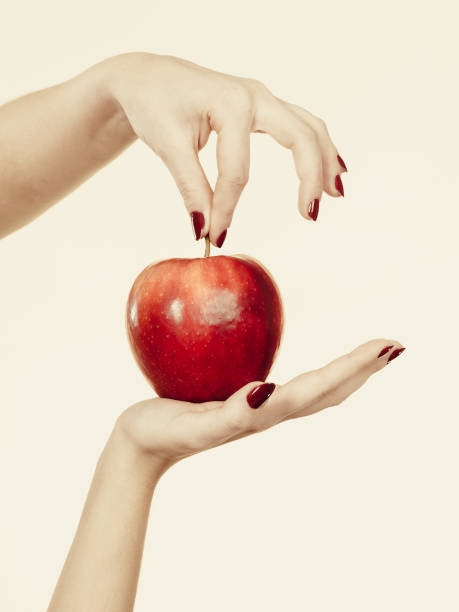 istock Woman hand holding delicious red apple 1009062544