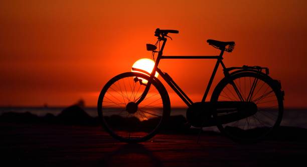 istock Old dutch retro bicycle on the beach against red sunset 1009063640