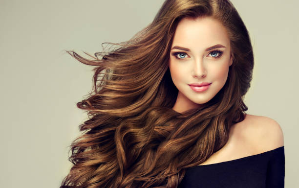 junge, braunen haaren schöne modell mit langen, lockigen, gepflegtes haar. ausgezeichnete haare wellen. friseur-kunst und haare pflege. - hair care straight hair hairstyle long hair stock-fotos und bilder