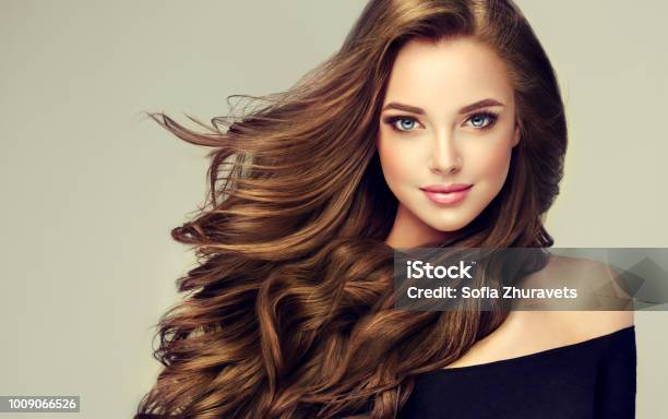 Young Brown Haired Beautiful Model With Long Curly Well Groomed Hair Excellent Hair Waves Hairdressing Art And Hair Care Stock Photo - Download Image Now