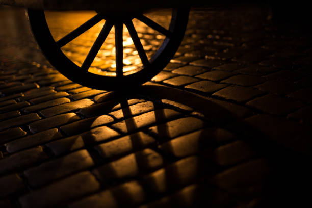 Old wooden wheel from horse cart. Main square in Cracov. Night