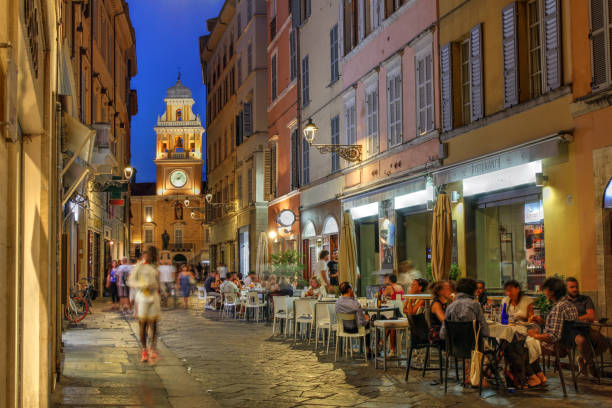 Parma, Italy Parma, Italy - August 9, 2017: Street scene in Parma, Italy featuring the Palazzo del Guvernatore (Guvernor's Palace) with people enjoying dinning out. parma italy stock pictures, royalty-free photos & images