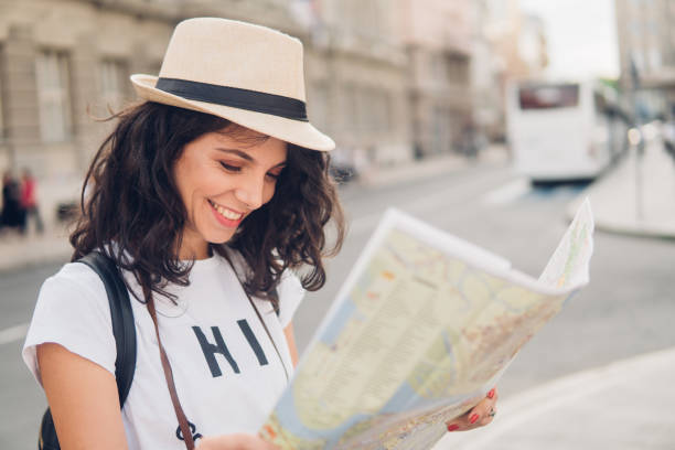 istock Gorgeous woman looking at touristic map and smiling 1009101108