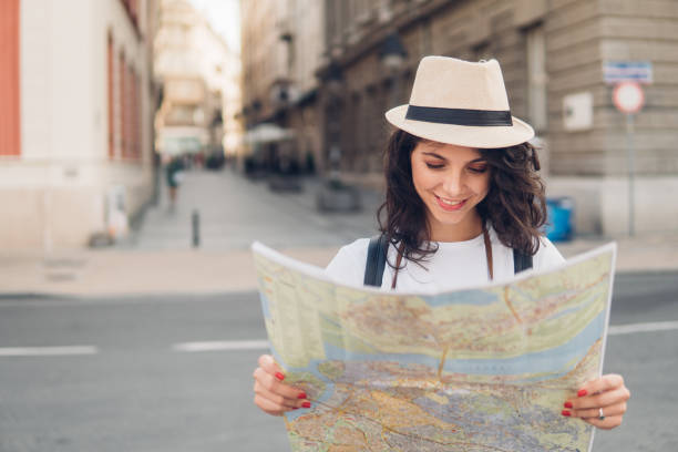 istock Smiling woman reading touristic map[ 1009101270