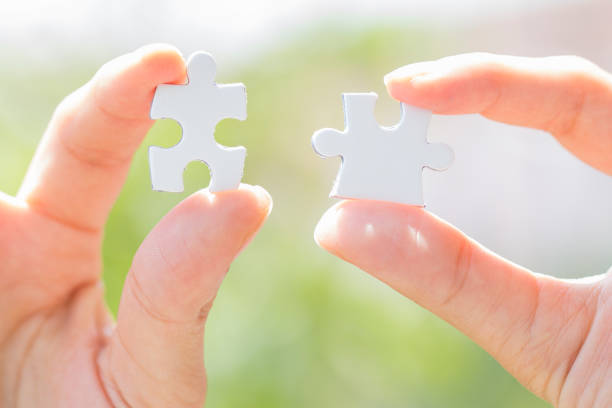 istock business people assembling jigsaw puzzle and represent team support and help concept. Building a business success. 1009121988
