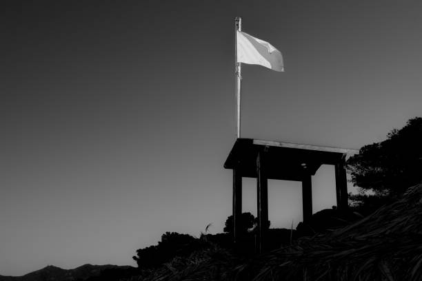 Silhouette of a look out tower and a white flag