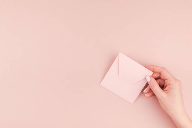 istock Woman hand holding small pink love letter 1009130234