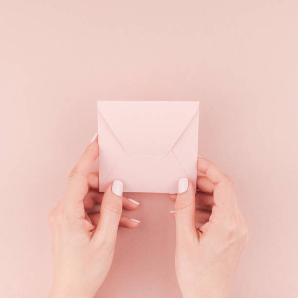 istock Woman hand holding small pink love letter 1009130258