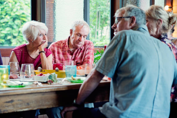 istock Group of seniors having dinner in summer house. 1009159724
