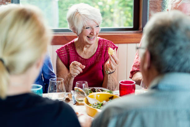 istock Group of seniors having dinner in summer house. 1009159792