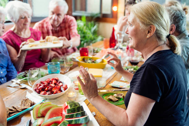 istock Group of seniors having dinner in summer house. 1009159854