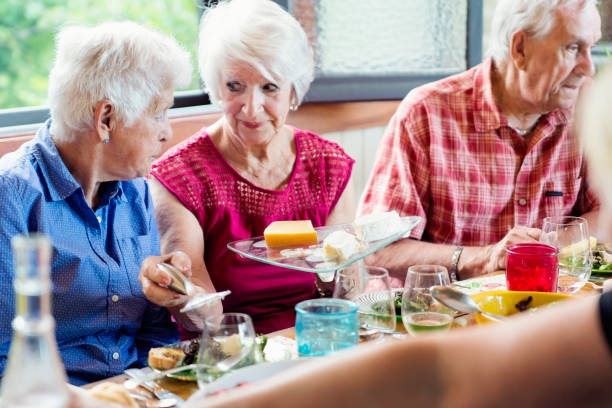 istock Group of seniors having dinner in summer house. 1009159878