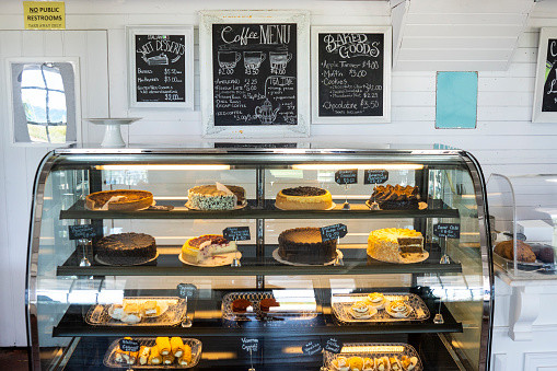 Luscious pastries and baked good in a retail display case in a cafe bakery coffee shop.