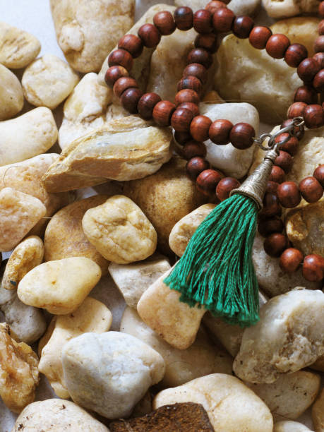 istock Wooden Buddha Beads on River Rocks 1009238686