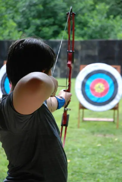 Youth boy taking aim at an archery target