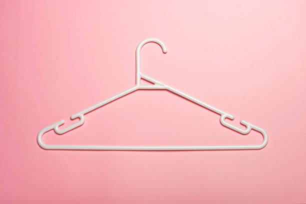 istock A white plastic clothes hanger isolated on pink background 1009252012