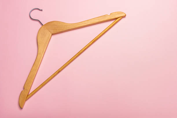 istock A wooden clothes hanger isolated on pink background 1009252022
