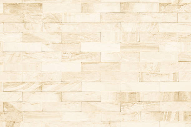 istock Cream and white brick wall texture background. Brickwork or stonework flooring interior rock old pattern clean concrete grid uneven bricks design stack. 1009257064