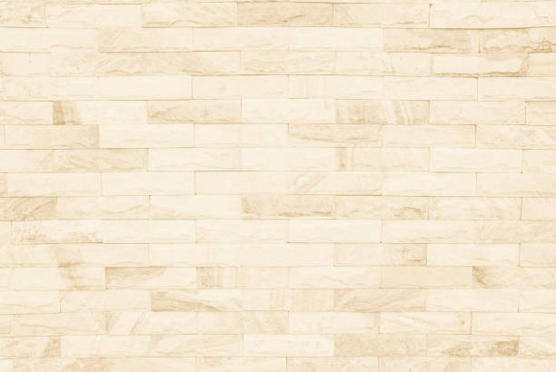 istock Cream and white brick wall texture background. Brickwork or stonework flooring interior rock old pattern clean concrete grid uneven bricks design stack. 1009257068