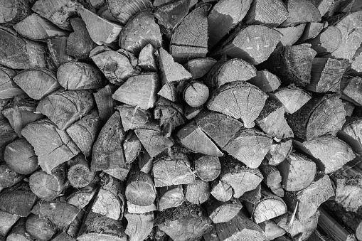 Black and white shot of firewood stacked. Suitable for backgrounds and textures