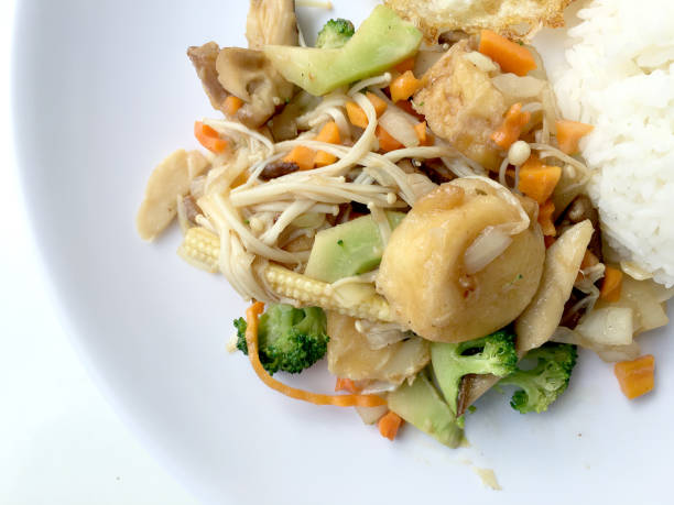 Stir fry yellow tofu and vegetable with rice and fried egg in white dish on white background for celebrate Chinese new year festival. Healthy food. Thai food.