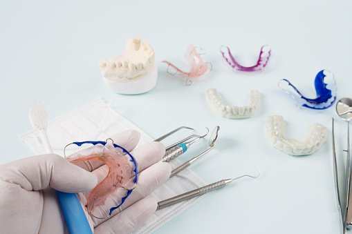 Dental  tools  and retainer orthodontic appliance on the blue background.
