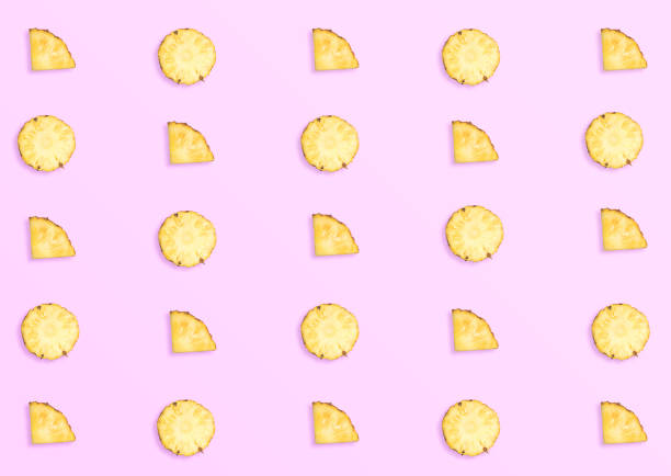 istock Pineapples on pink background. Pattern made of sliced pineapples. top view minimal 1009281870