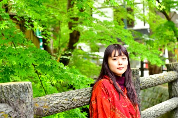 istock Young Japanese Woman Surrounded by Fresh Green Maple Foliage 1009286510