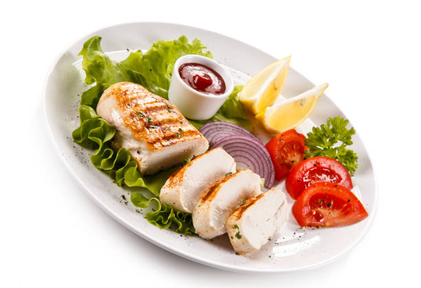istock Grilled chicken breast and vegetables on white background 1009286744