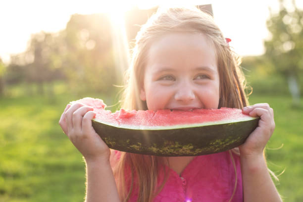 Cute girl eating watermelon stock photo