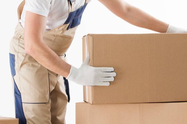 istock Relocation services concept. Mover in uniform with cardboardboxes isolated on white background 1009314244