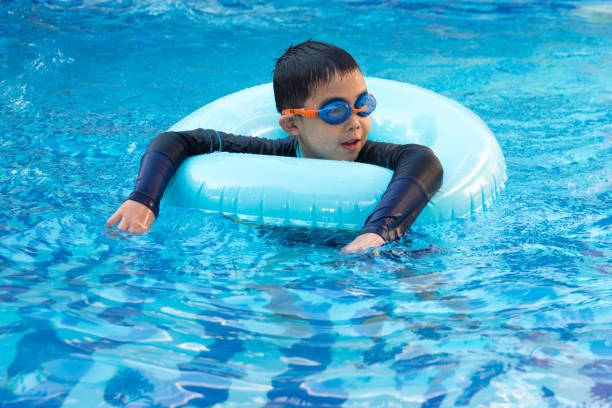 istock young boy swimming in pool. 1009336678