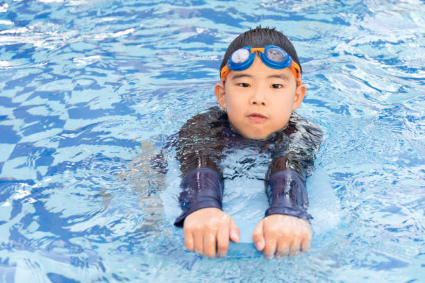 istock young boy swimming in pool. 1009336690