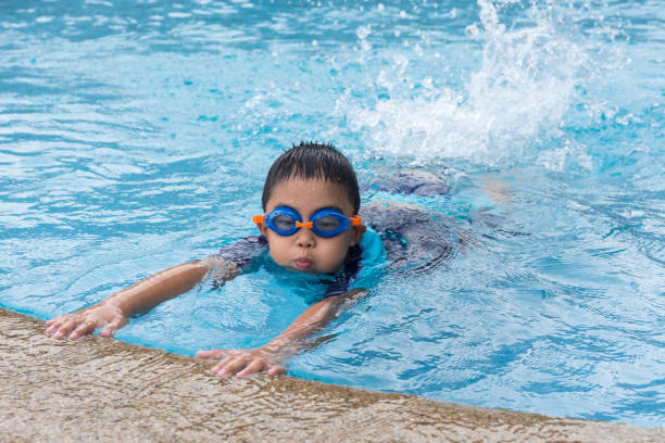 istock young boy swimming in pool. 1009336716