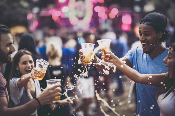 gruppe von fröhlichen freunden spaß mit bier auf ein konzert. - festival alcohol stock-fotos und bilder