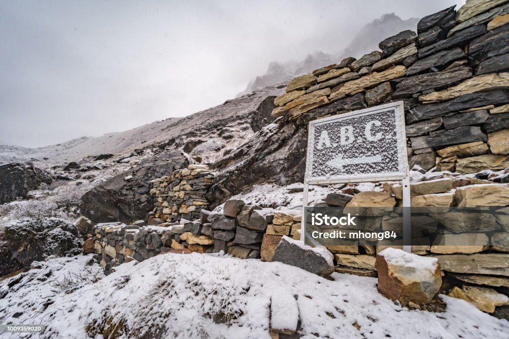 Signpost to Annapurna Base Camp (A.B.C.) at Machhapuchhre Base Camp (M.B.C.) with snow Annapurna Conservation Area Stock Photo