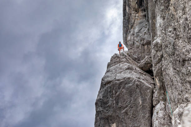 istock Rock climber ist standing on rock in big wall 1009362544