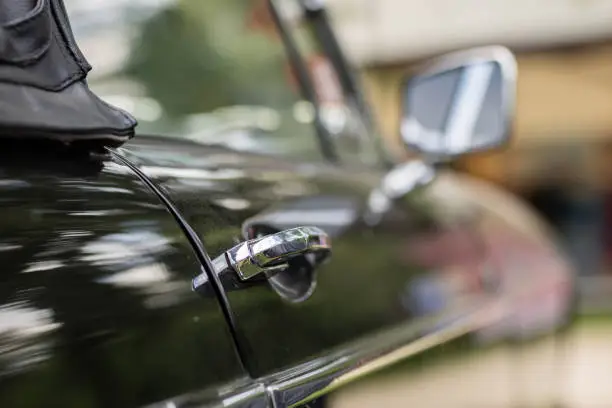 Photo of Chrome mirror in an old car. Accessories in cars exhibited at shows. Season of the summer.