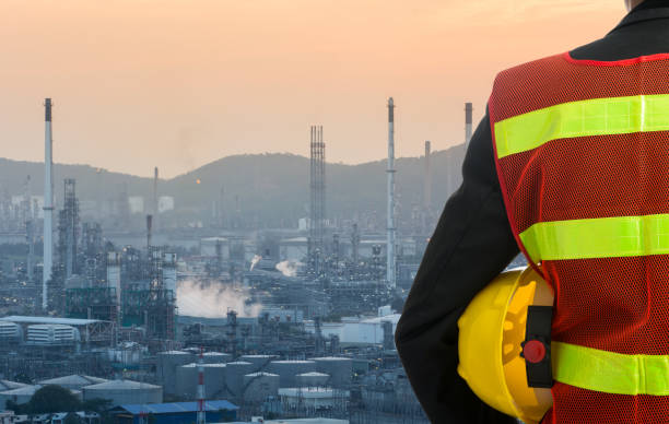 istock Hand or arm of engineer hold yellow plastic helmet 1009372172