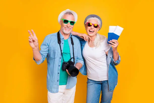 Photo of Tourism tourists traveler journey rest weekend vacation holiday relax concept. Photo portrait of excited guy two fingers digicam  lady vip passengers showing document with tickets isolated background