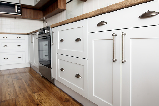 Elegante gris maneja en primer plano, interior de cocina gabinetes con electrodomésticos de acero inoxidable y muebles modernos. diseño de cocina en estilo escandinavo photo