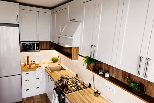 istock Modern Kitchen design in scandinavian style. stylish light grey kitchen interior with modern furniture and stainless steel appliances. wooden countertop, steel stove, board,knife and spices 1009383798