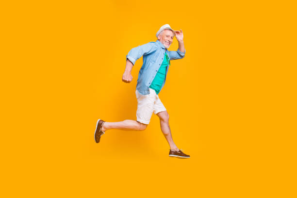 istock Happiness emotion facial expressing hold hand empty place concept. Turned full length size view photo portrait of cheerful excited lovely cute handsome gentleman jumping up isolated vivid background 1009384204
