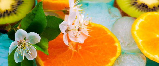 istock banner for website, kiwi and Mandarin close on a blue background with ice 1009387422