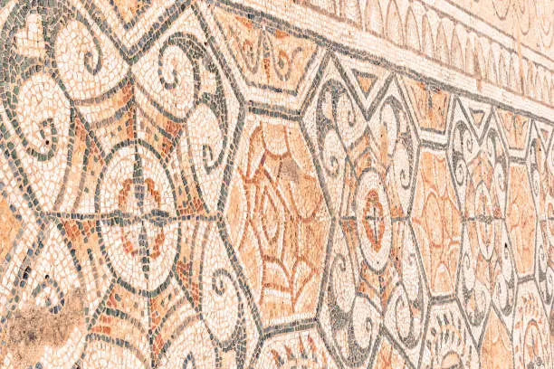Roman mosaic of symmetrical, interlocking patterns.  A few dozens of kilometres to the southwest of Cagliari lies one of Sardinia’s most important archaeological sites, Nora.  Once a a prosperous city, Phoenician first, Carthaginian later, and finally a Roman centre.  Excavations began in 1889, when a coastal storm revealed a Phoenician-Punic cemetery.  The floors of Roman buildings were often richly decorated with mosaics - tiny coloured stones (tesserae).
