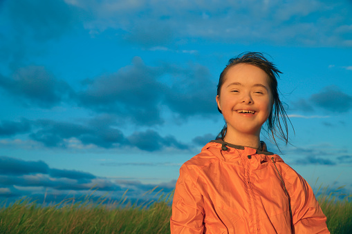 Portrait of little girl smiling on background of blue sky
