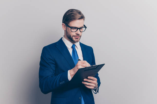 istock Ceo message conference idea decision plan executive leader people person concept. Portrait of confident serious smart inspector making notes to the clipboard isolated on gray background copy-space 1009414518