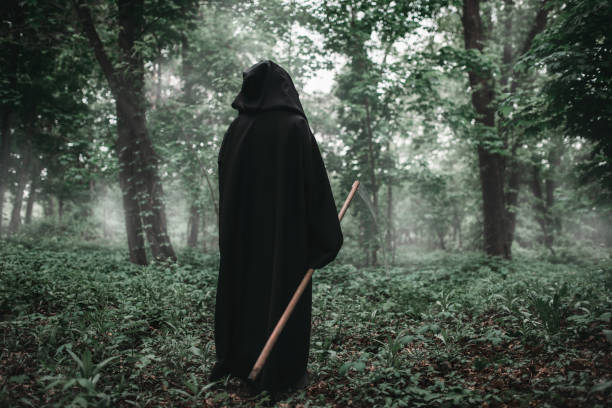 istock Death with a scythe in the dark misty forest 1009424080