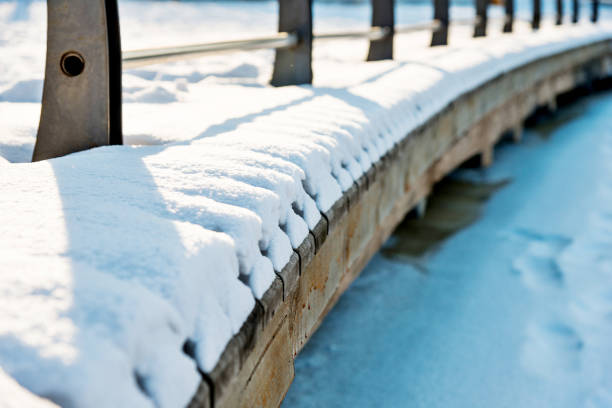 The bridge on the lake is covering with snow.