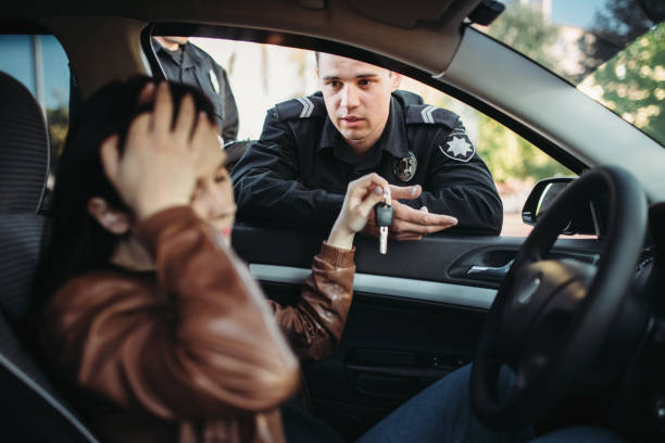 istock Male cop in uniform check female driver on road 1009424586